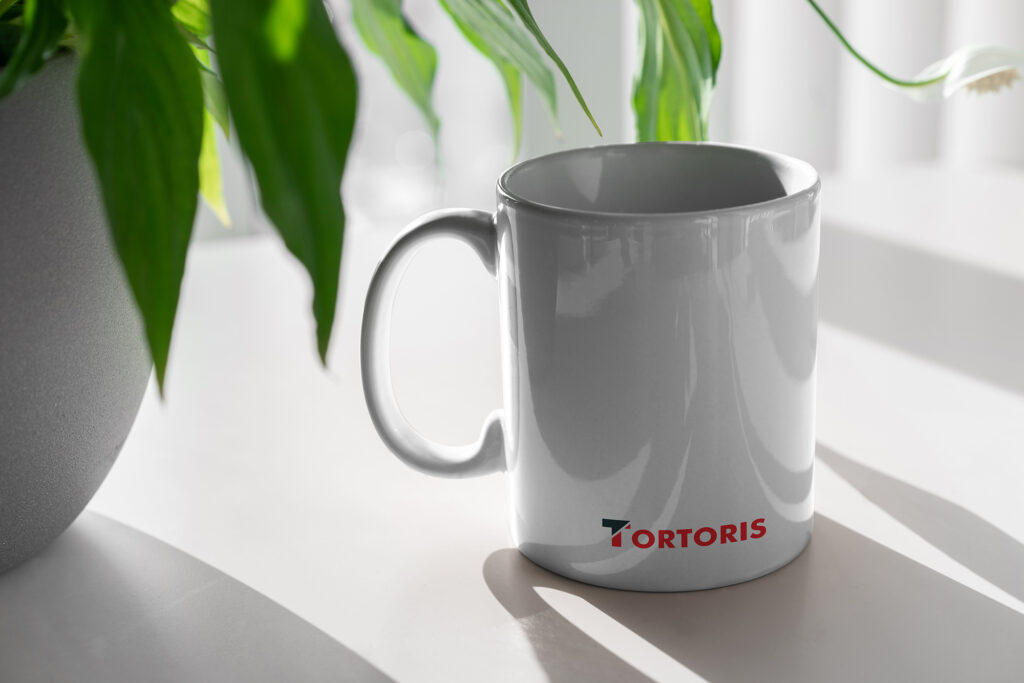 Projekt logo Tortoris - wizualizacja na kubku firmowym
